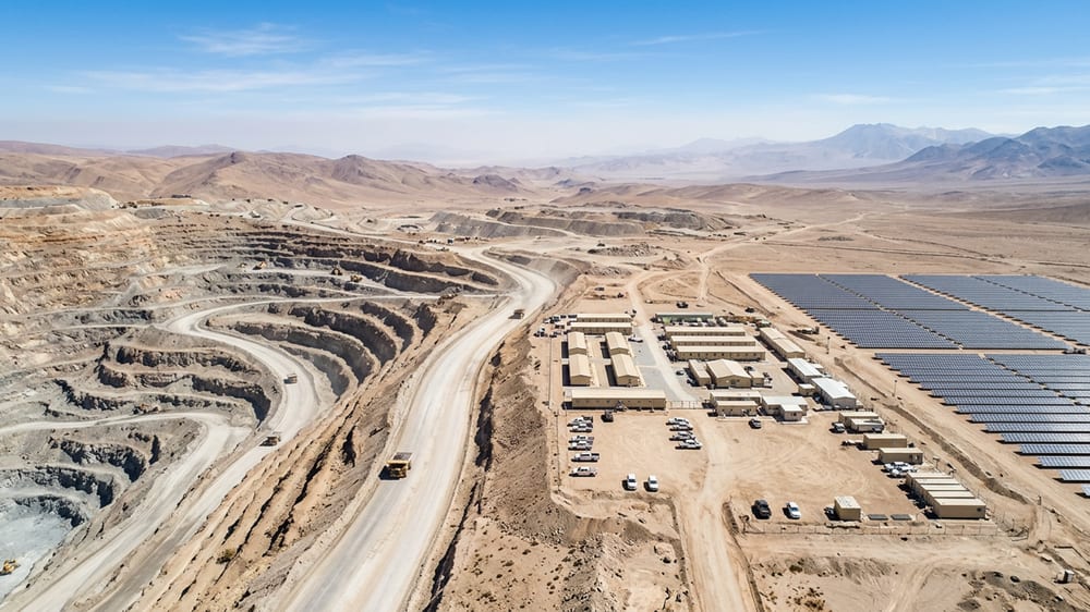 Aerial photograph of a remote mine site with a solar field, a workforce camp and a haul road