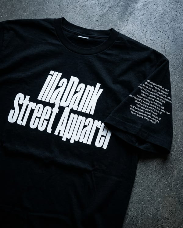 Changes Tee Single Edit — black short-sleeve tee with lyric print sleeve detail, worn in an urban street setting