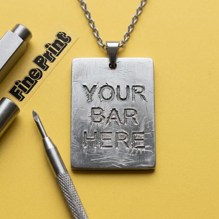 Close-up of a line freshly engraved into a brushed stainless steel bar