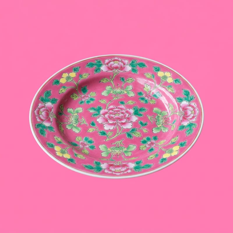 A hand-painted Peranakan porcelain plate with a floral pattern