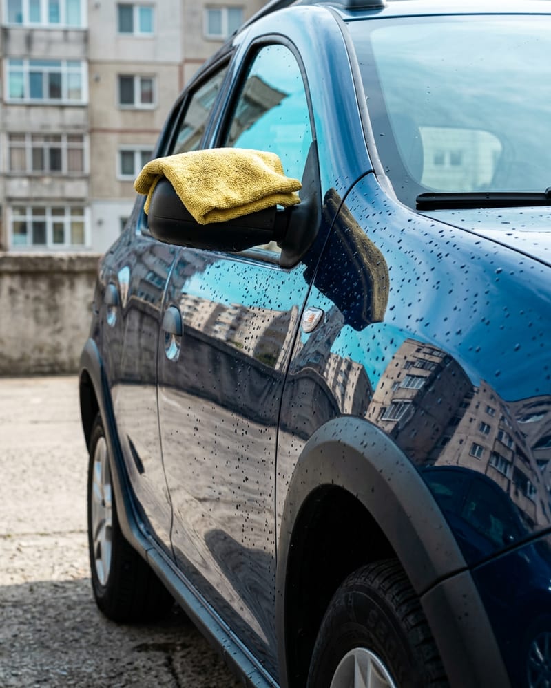 Mașină curată, cu apa perlată pe vopsea, ștearsă cu o cârpă din microfibră