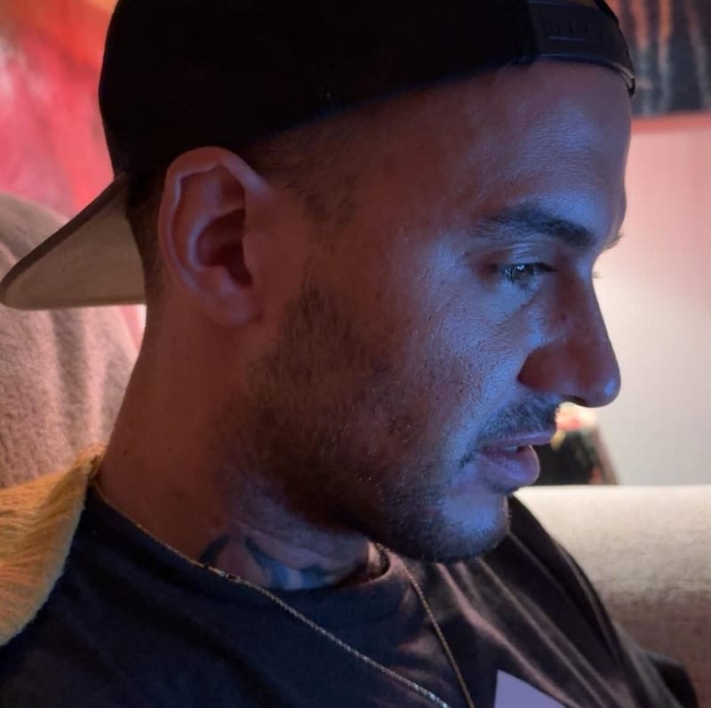 $HELTA side profile in blue light, neck tattoo visible